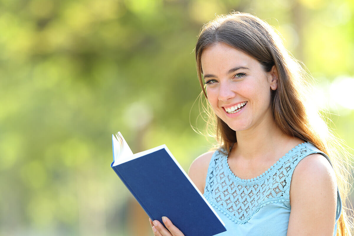girl reading a book and smiling