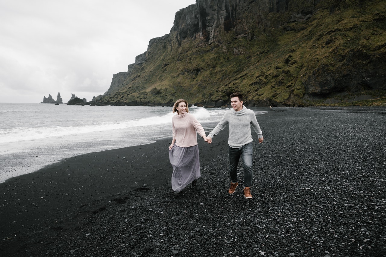 A couple holding hands on a seashore