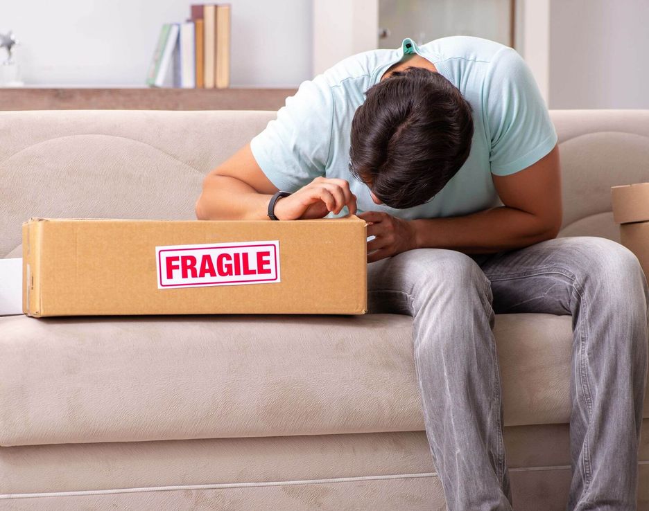 A man putting the fragile label on a box