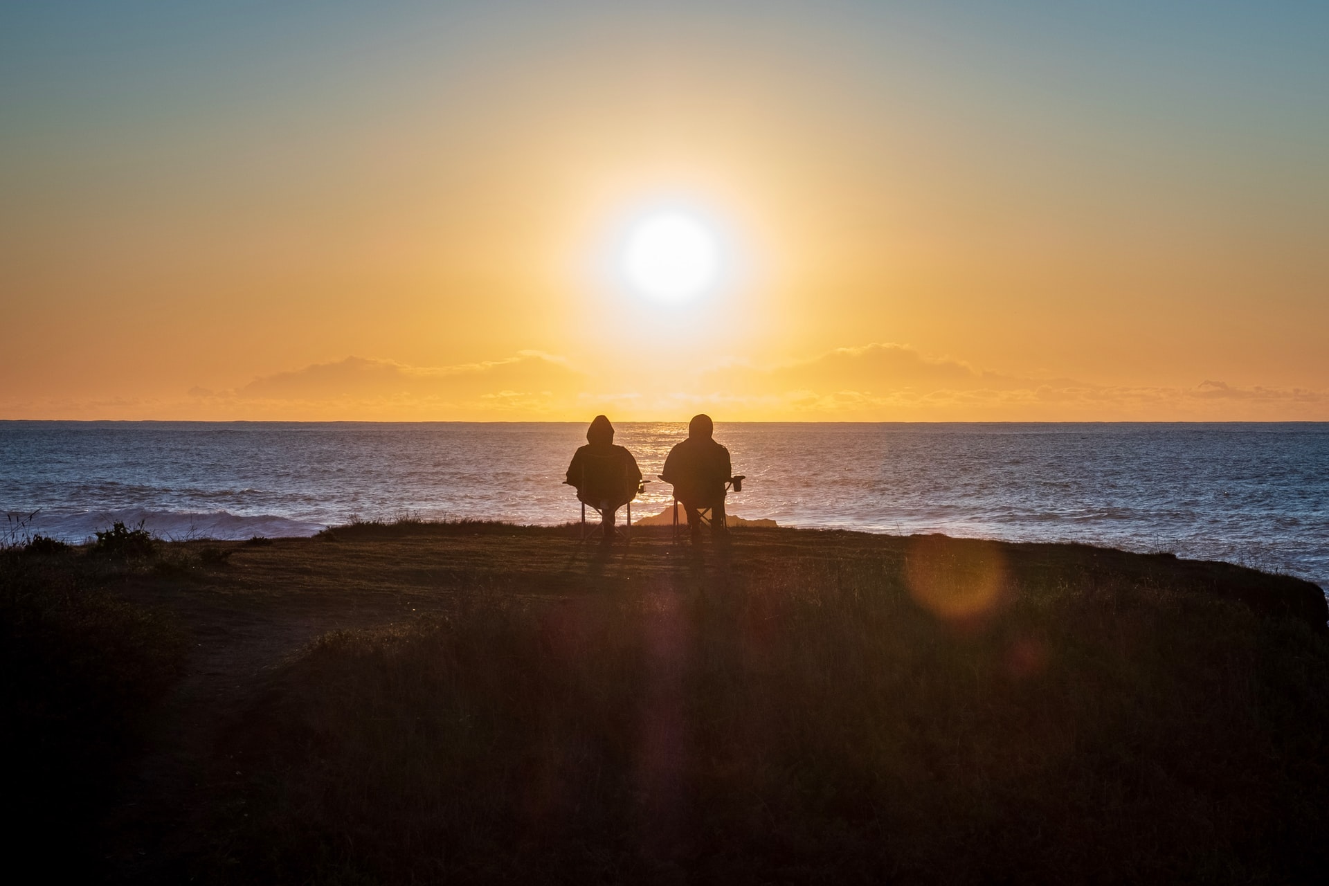Two people enjoying sunset at the beach
