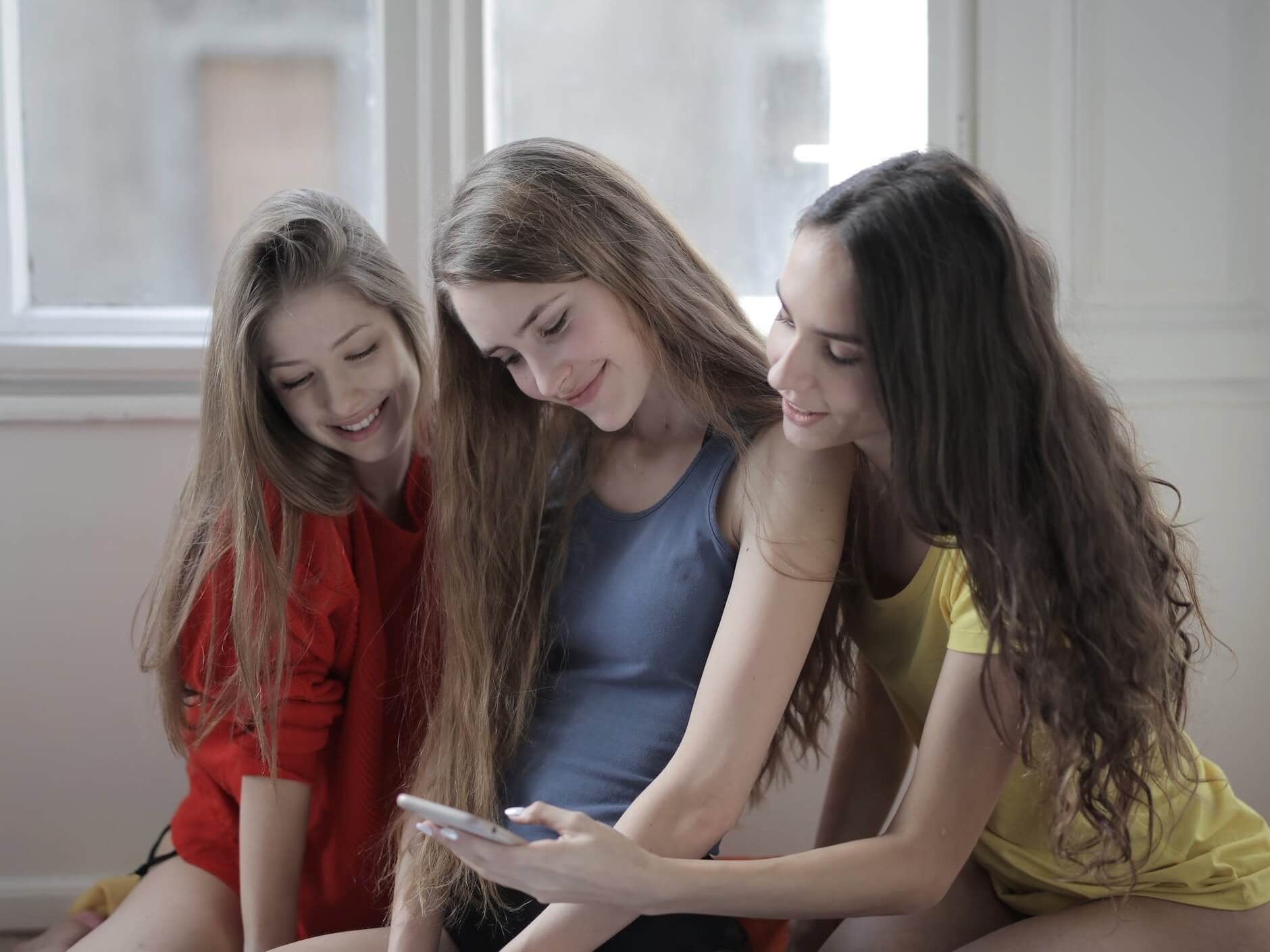 Three girls looking at a phone