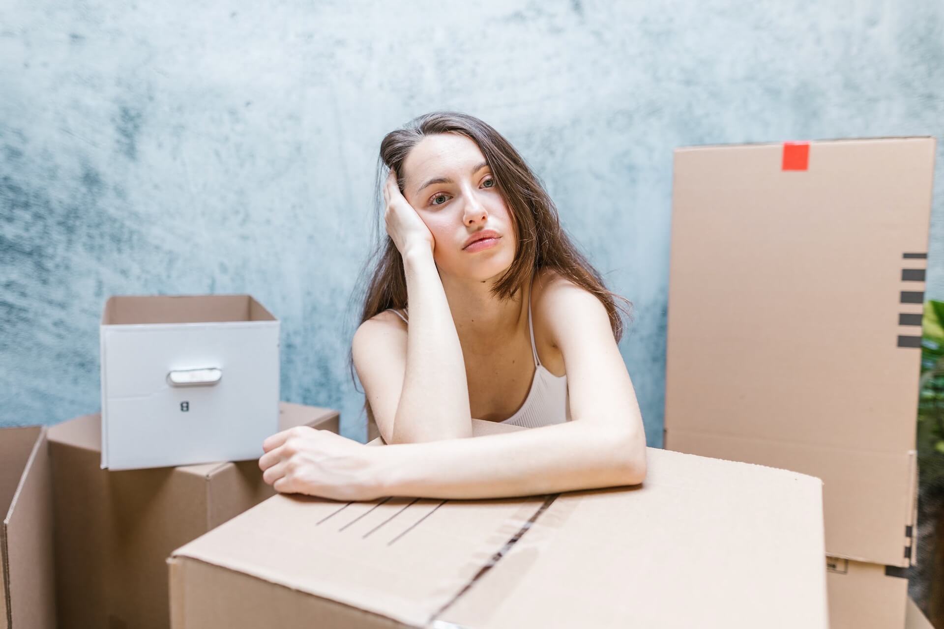 A worried woman leaning on a box