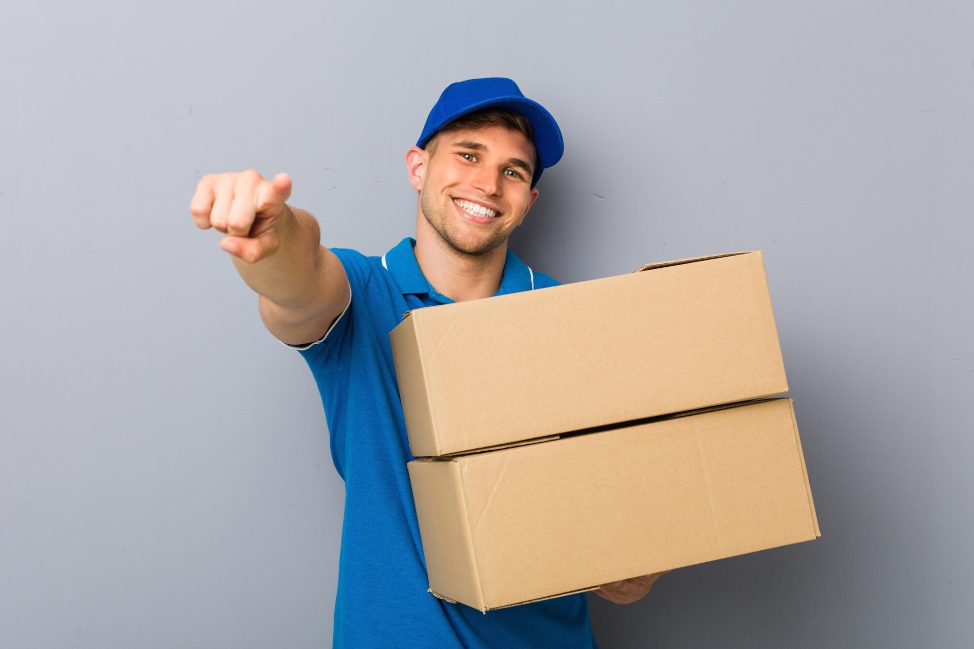 A mover pointing and holding a box