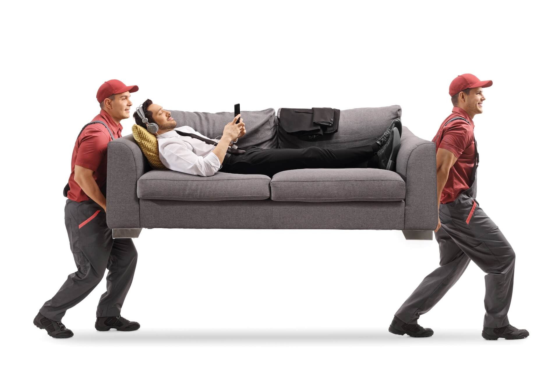 Two movers carrying a couch with a man lying on it