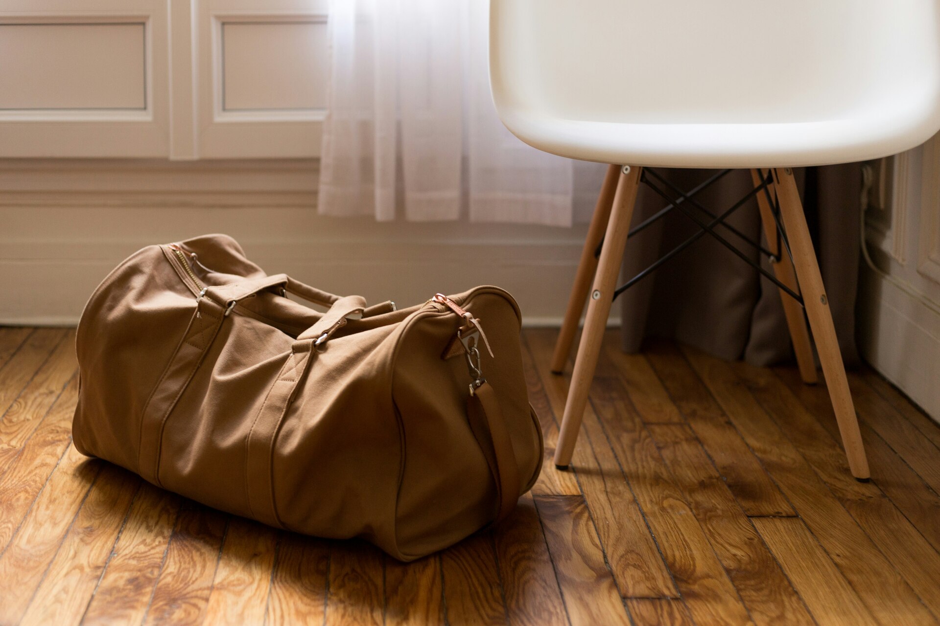 A duffel bag on the floor next to a chair